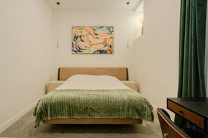 A bedroom with a bed, a green blanket, a wooden headboard, a painting on the wall, and a green curtain. - 110m2 3bd Luxury last Paganini apt in Old Nice (Nice)