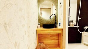 A bathroom with a wooden vanity, a black sink, a mirror, and a shower area. - KIN'S HOUSE (Osaka)