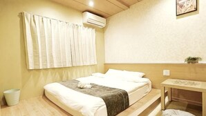 A bedroom with a bed, bedside table, and a small potted plant. - KIN'S HOUSE (Osaka)