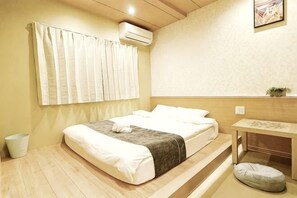 A bedroom with a bed, bedside table, and a small potted plant. - KIN'S HOUSE (Osaka)