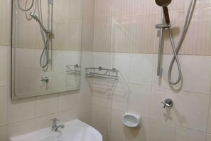 Un baño con lavabo, espejo y ducha.