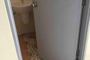 A bathroom with a sink and patterned floor tiles. - Phuket Town Budget House - Aircon Room #1 (Phuket)