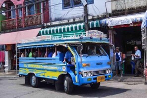 Un autobús azul y amarillo estacionado en una calle con edificios al fondo.