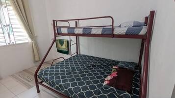 A bunk bed with a patterned mattress, a pillow, and a blanket.