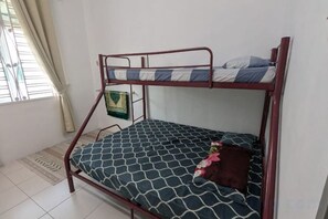 Ein Etagenbett mit einem gemusterten Matratze, einem Kopfkissen und einer Decke.