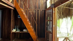 A wooden interior with a staircase, large windows, and a woven light fixture. - Iraboti Eco Resort & Research Center (Dacope)