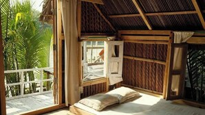 A wooden room with a bed, a window, and a view of greenery outside. - Iraboti Eco Resort & Research Center (Dacope)