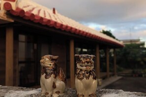Deux statues de lions en céramique se dressent devant un bâtiment dont le toit est recouvert de tuiles rouges.