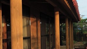 Ein Gebäude mit großen Holzsäulen und Glastüren.