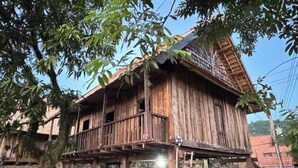 Une maison en bois dotée d’un balcon et d’un escalier menant à un étage supérieur.