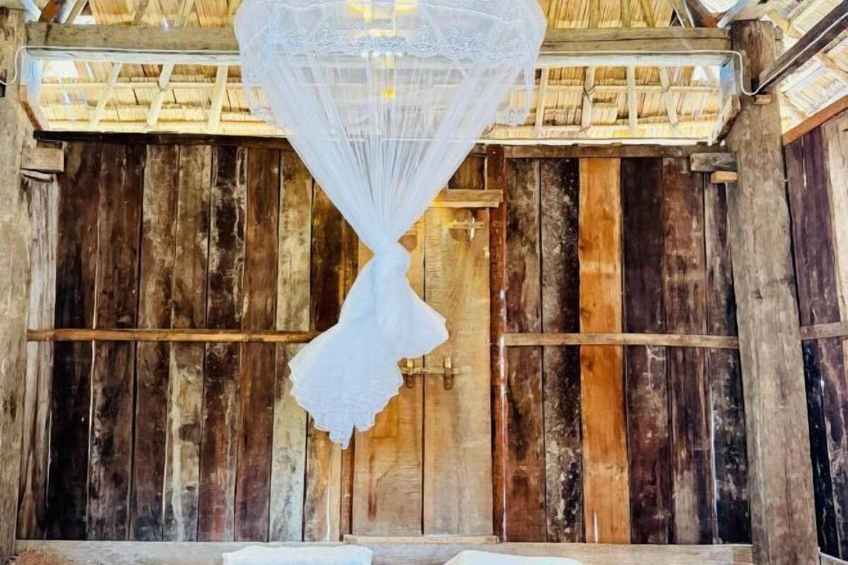 Una habitación rústica de madera con un dosel blanco de encaje colgando.