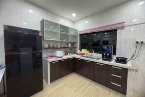A modern kitchen with a refrigerator, microwave, and coffee maker.