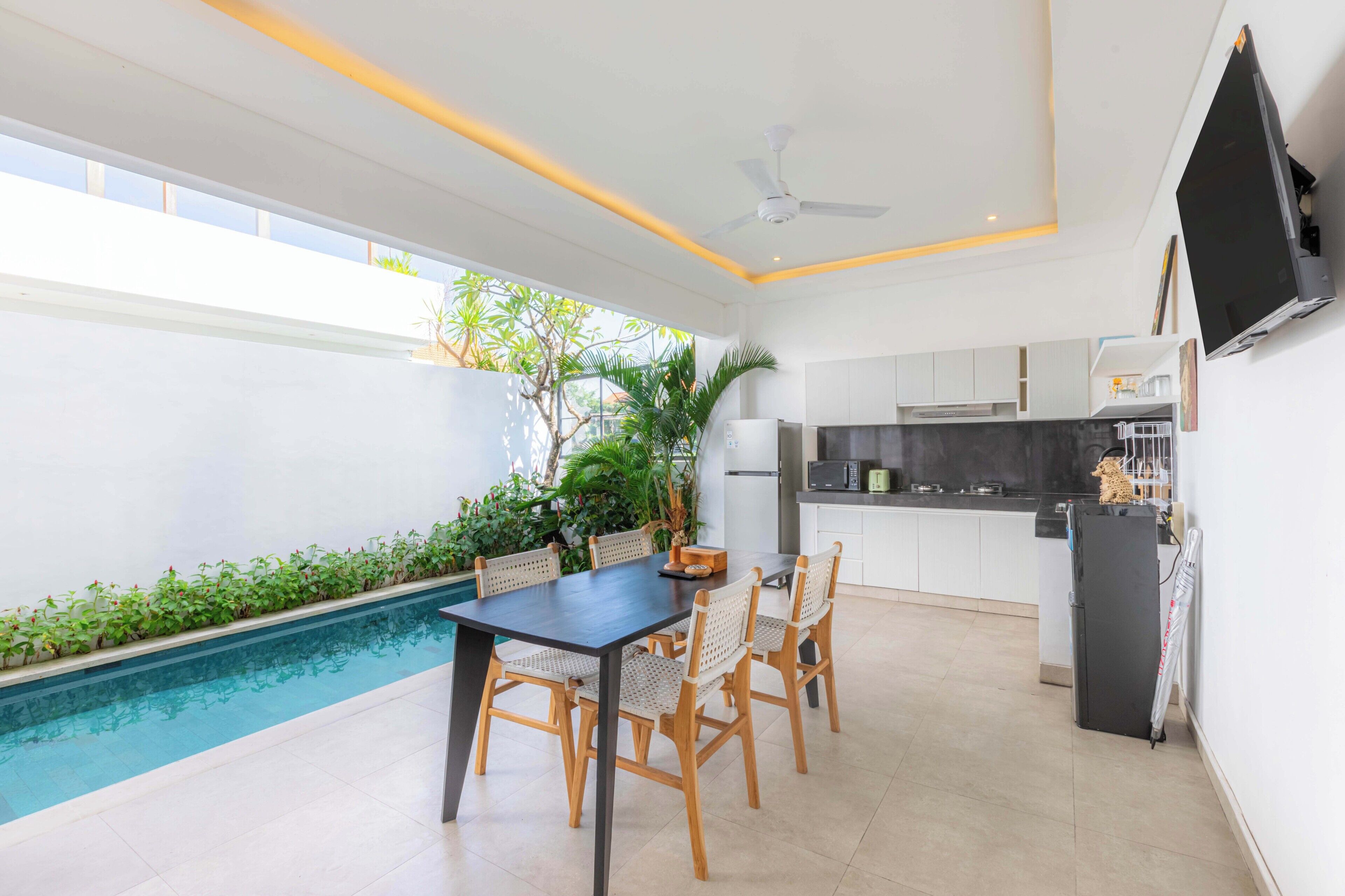 A modern kitchen with white cabinets, a black countertop, and a built-in oven.