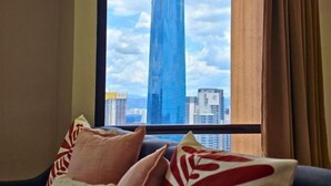 A room with a large window overlooking a tall building and other cityscape. - Berjaya Times Square 1BR Suite 5Pax Bukit Bintang Steps to Monorail (Kuala Lumpur)