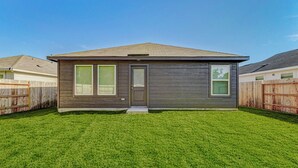 A single-story house with a front door, two windows, and a small front porch.