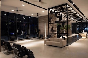 A modern hotel lobby with a seating area, a reception desk, and a decorative wall. - Expressionz#KLCC#1BR#Skypool#NEW (Kuala Lumpur)