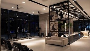 A modern lobby with a seating area, a reception desk, and a geometric decorative partition. - Expressionz#KLCC#1BR#Skypool#NEW (Kuala Lumpur)
