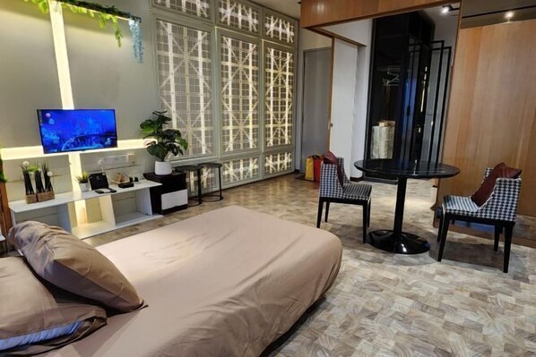 A modern hotel room with a bed, a desk, a chair, a TV, and a decorative wall. - Expressionz#KLCC#1BR#Skypool#NEW (Kuala Lumpur)