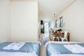 A hotel room with two beds, a desk, and a chair. There is a kitchenette in the background. - CROWN OOJIMA (Tokyo)