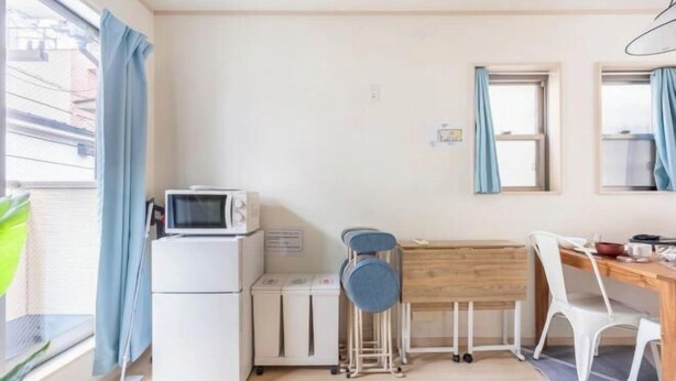 A compact room with a kitchenette, a small dining table, a chair, a microwave, and a window with curtains. - CROWN OOJIMA (Tokyo)