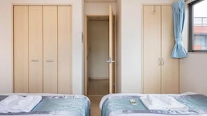 A hotel room with two beds, a wardrobe, and a bathroom door. - CROWN OOJIMA (Tokyo)