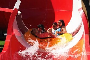 Eine Wasserrutsche mit Personen in aufblasbaren Röhren.