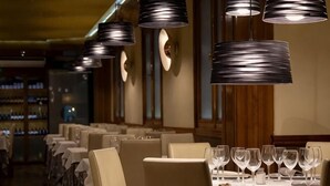 Ein Restaurant mit mehreren Tischen, an jedem Tisch Weingläser und Geschirr.
