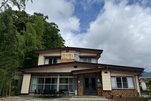 A two-story building with a sign indicating it is a restaurant. There are windows on the ground floor, and the building has a flat roof. - Bamboo Yado A (Fujikawaguchiko)