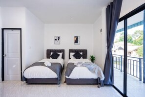 A bedroom with two beds, a door, and a balcony with a view. - The Moment Pool Villa (Sattahip)
