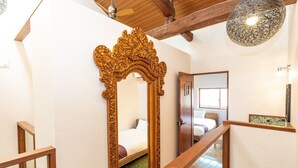 A staircase with a wooden handrail, a large ornate mirror, and a ceiling fan. - Kyobu Higashiyama (Kyoto)