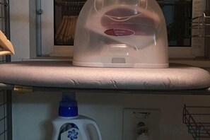 Egy fehér színű háztartási gép, valószínűleg egy kávéfőző, a konyhapulton.