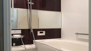 A bathroom with a white bathtub, a mirror, and a shower area. - 3BR - Shinjuku area, 5mins from station (Tokyo)