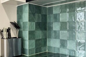 A corner of a room with green tiles and a utensil holder with knives. - Emily Home 3BR Old Town Chiang Mai by Beginning With (Chiang Mai)