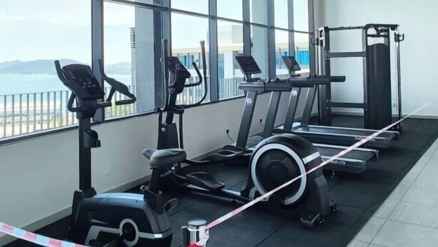 A gym with cardio machines, weightlifting equipment, and large windows offering a view of the sea. - Jesselton Quay Central Citypad (Kota Kinabalu)