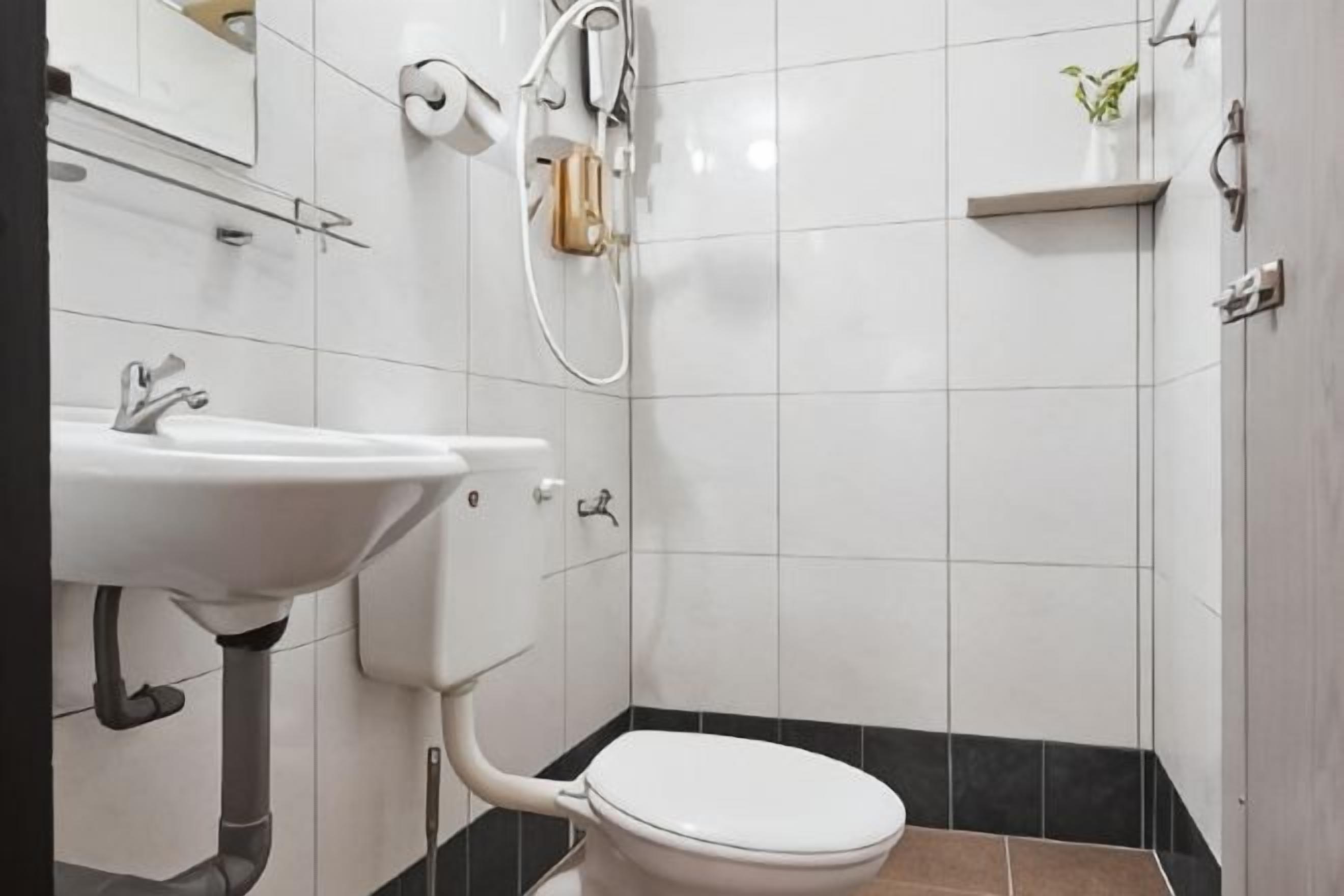 A bathroom with a white sink, toilet, and shower.