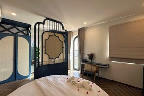 Een hotelkamer met een bed, een bureau en uitzicht op de omgeving.