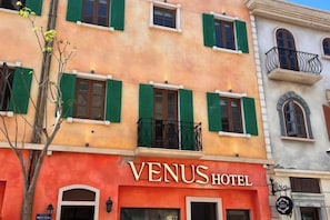 A hotel with a red facade and green shutters, named VENUS HOTEL. - VENUS HOTEL PHU QUOC (Phu Quoc Island)