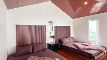 A modern bedroom with two beds, wooden headboards, a nightstand, and a window with a view.