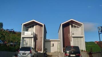 A modern building with two garage doors, a parked car, and a motorcycle.