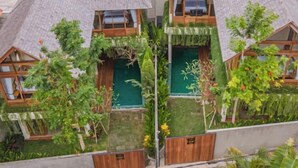 A house with a sloped roof, wooden windows, and a garden with various plants. - 2 Bedroom Villa Avyathi (Bali)