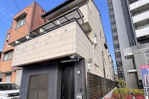 A multi-story building with a garage door, a brick facade, and a modern design.