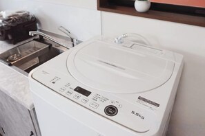 A white electric kettle with a digital display and control buttons, placed on a kitchen counter. - Sumiyoshinoyado (Osaka)