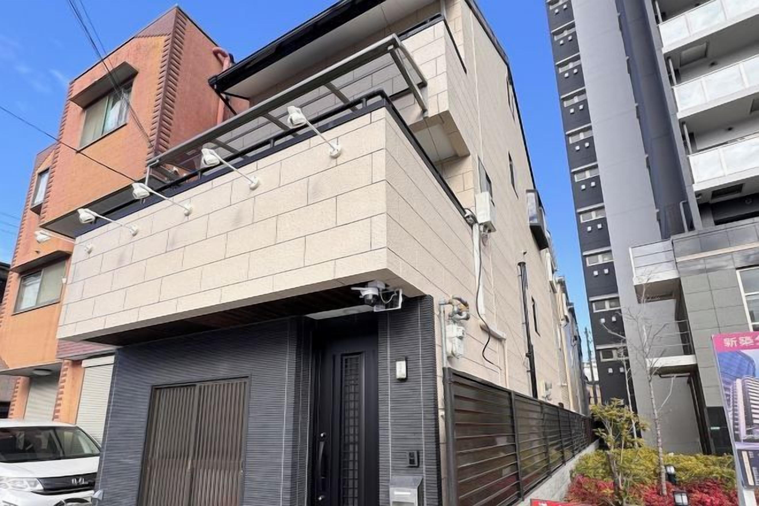 A multi-story building with a garage door, a balcony, and a clear sky.