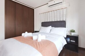 A hotel room with a bed, bedside tables, a wardrobe, and a window with curtains. - Sumiyoshinoyado (Osaka)