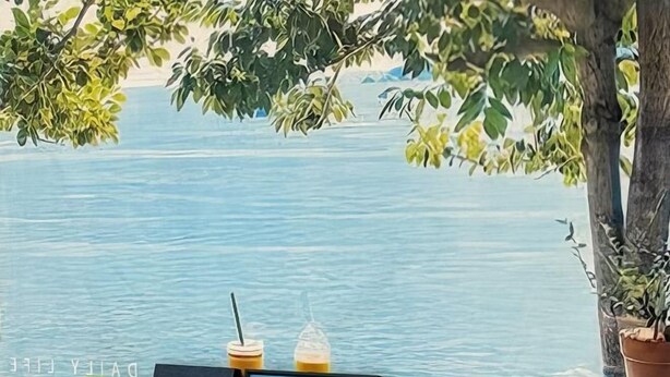 A view of a calm body of water with a wooden table and a potted plant. - Chen inn Boutique House Patong (Phuket)