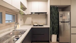 A compact kitchen with a built-in stove, a sink, and a refrigerator. - Mount Air Condo (Seoul)