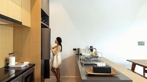 A modern kitchen with wooden cabinets, a black countertop, and a person standing by the counter.