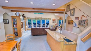 A spacious living area with a kitchen, a dining table, and a sofa. - River Bend Retreat (Bonneville County)