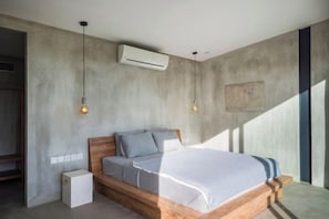 A bedroom with a wooden bed, bedside tables, an air conditioning unit, and pendant lighting. - Samsara Villa with Rice Field View (Bali)