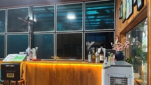 A reception area with a wooden counter, a Visa machine, and a large air conditioning unit. - Tam Coc Mandala Villa (Hoa Lu District)